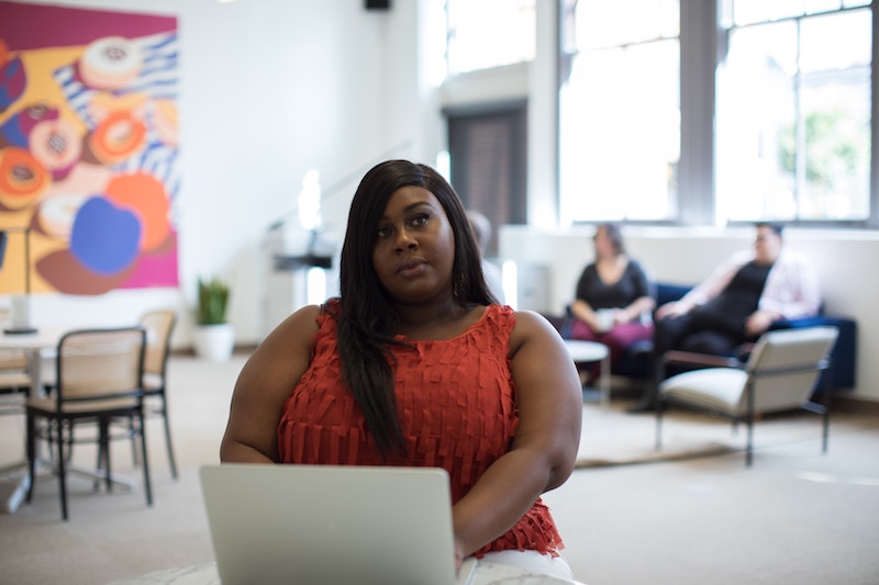 Woman on laptop in a corporate space.